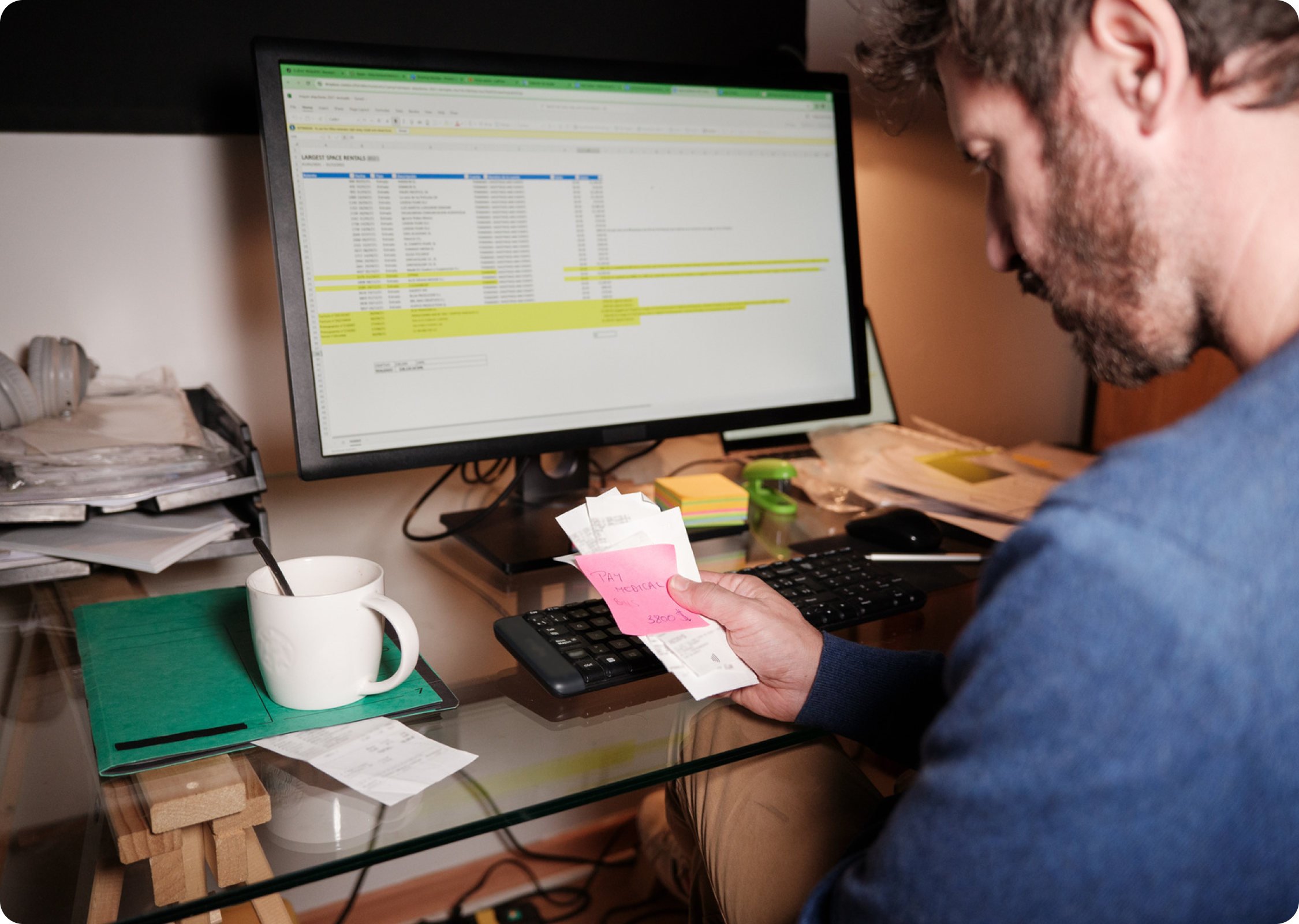 Renter looking at bills and budgeting materials, reflecting financial stress tied to rent timing.