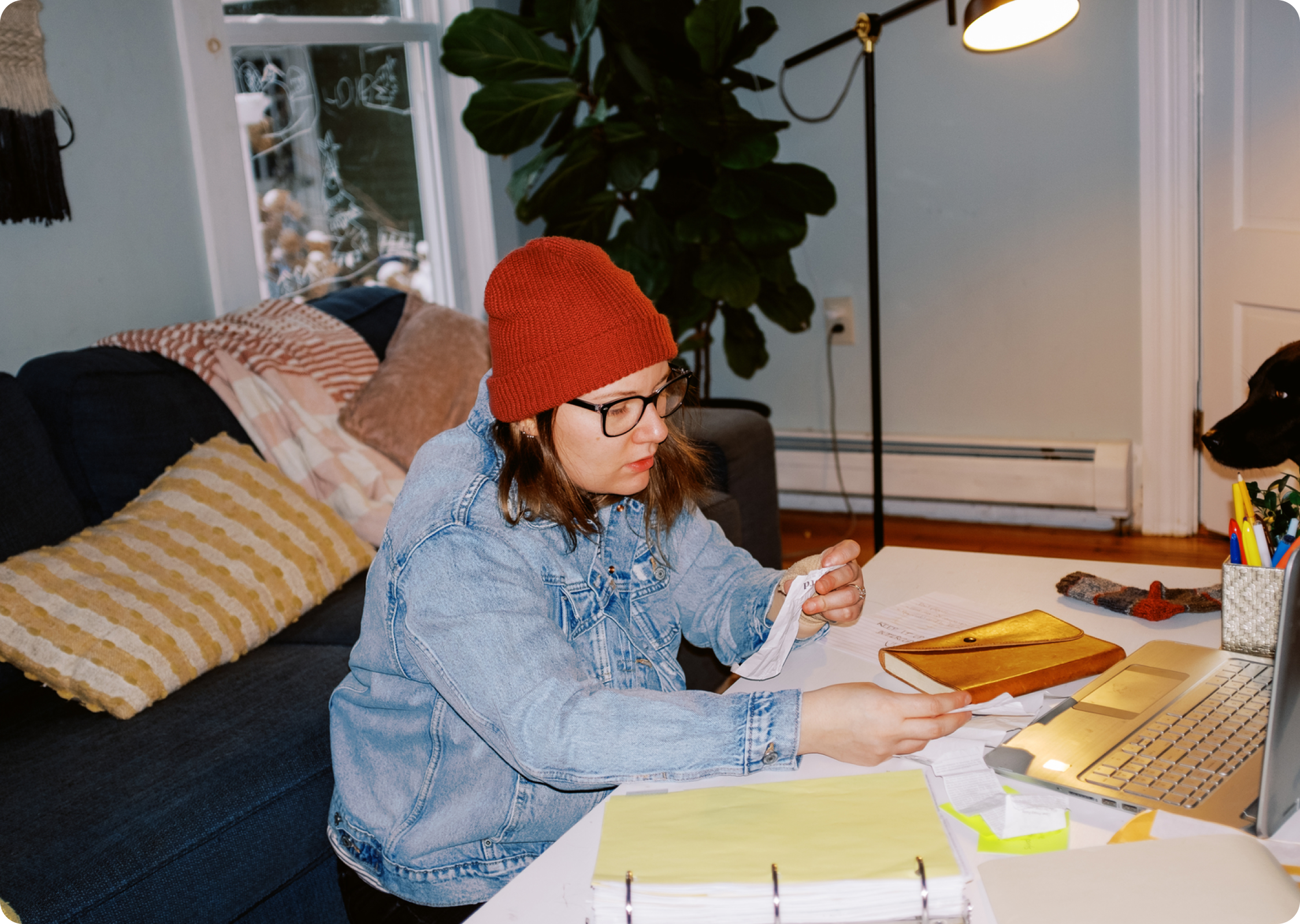 Renter reviewing bills and paperwork at home while working on a laptop.